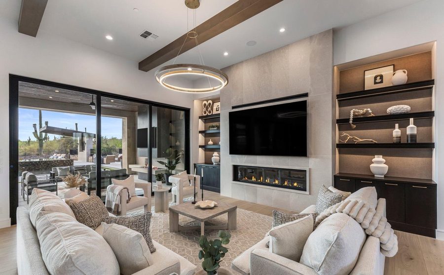 Living room with a linear fireplace opening to a Sonoran Desert patio