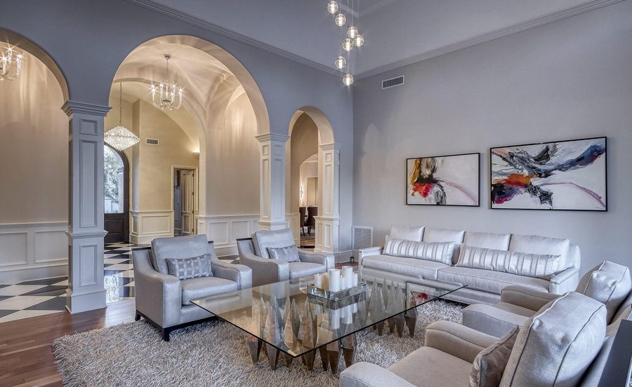 Formal living room with arched openings and a coffered entry beyond
