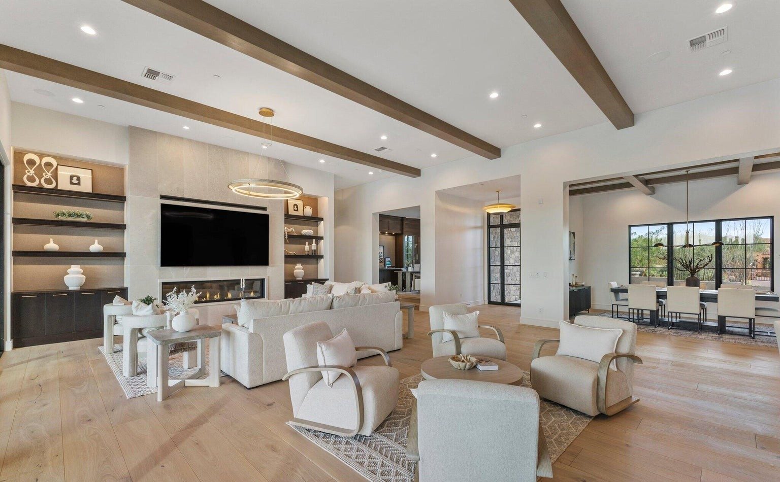 Open great room with exposed beams and a linear fireplace