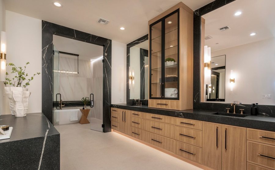 Primary bath with black marble surrounds and white oak vanities